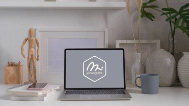 Çalışma masasının görünümünü bilgisayarla, kitaplarla, kırtasiyeyle ve dekorasyonla kapat. 