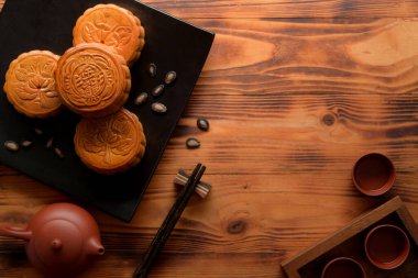 Çay takımlı kırsal masa manzarası, boş seramik tabakta ay çörekleri ve fotokopi alanı. Ay pastasındaki Çince karakter İngilizcede 