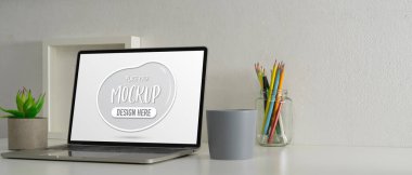 Dizüstü bilgisayar, kalem, dekorasyon ve kopyalama alanı ile kırpılmış çalışma masası görüntüsü 