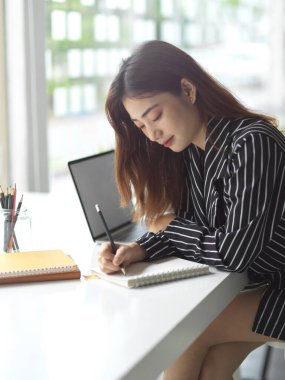 Ofiste çalışırken kağıt işleriyle ilgili bilgi okuyan kadın ofis çalışanının yan görüntüsü 