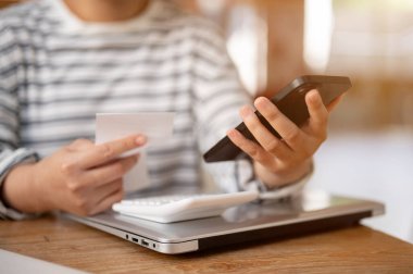 Bir kadının masadaki akıllı telefonunu kullanırken çekilmiş bir fotoğrafı. İnsanlar ve kablosuz teknoloji kavramları