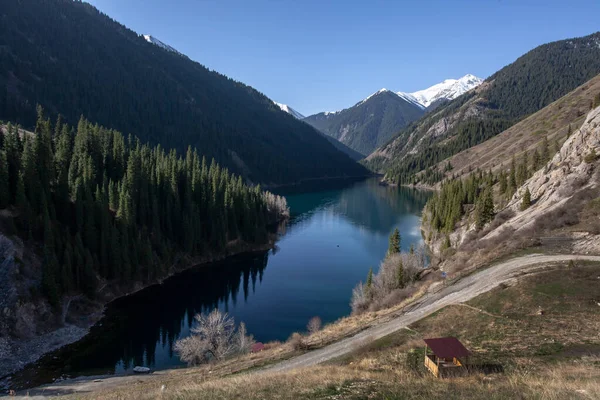 Montanha Lago Contra Fundo Picos Cobertos Neve Uma Floresta Densa — Fotografia de Stock