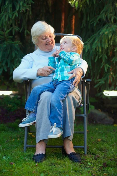 夏日傍晚 祖母和孙子在花园里 — 图库照片