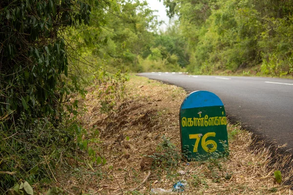 Belle route Ghat avec Milestone indiquant la distance à Kollegal (en tamoul) le long de la chaîne de montagnes de Talamalai Reserve Forest, Hasanur, Tamil Nadu - frontière de l'État du Karnataka, Inde — Photo