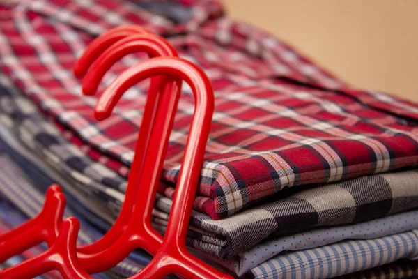 Vikta skjortor staplade över varandra efter strukit tillsammans med galgar — Stockfoto