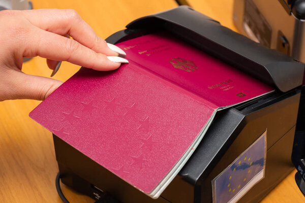 The process of scanning a German biometric passport to register 