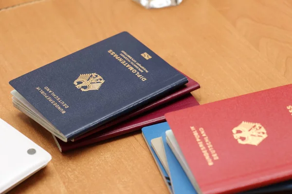 German diplomatic passport and others on a wooden table, close-u — Stock Photo, Image