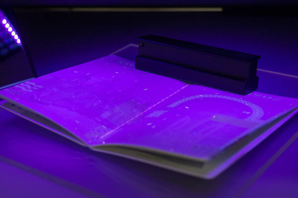 Проверка паспорта на мошенничество в ультрафиолетовом свете, обнаружение люмина
