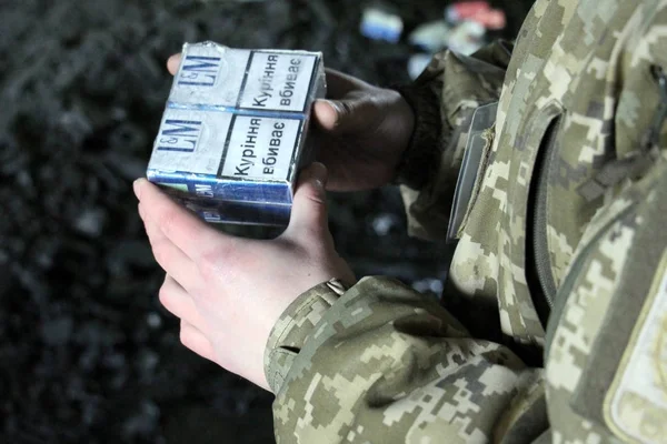 O guarda de fronteira em uniforme de camuflagem detém cigarro de contrabando — Fotografia de Stock