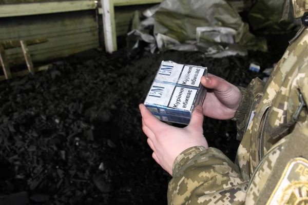 O guarda de fronteira em uniforme de camuflagem detém cigarro de contrabando — Fotografia de Stock