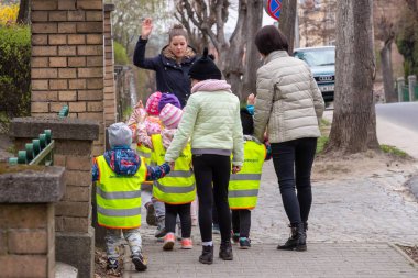 Vurgu sarı yansıtıcı giymiş okul öncesi çocuk grubu