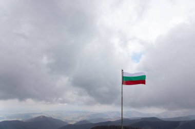 Frozen waving bulgarian flag with a beautiful view of stara planina, the biggest mountain of Bulgaria
