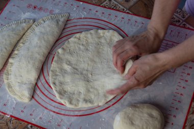 Ev yapımı ekmek ve börek için hamur yapan bir kadının ellerini kapat. Kadın fırıncı silikon bir fırında ekmek hazırlıyor.