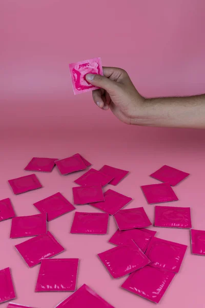 분홍색 배경에 콘돔을 테이블 분홍색 콘돔을 — 스톡 사진
