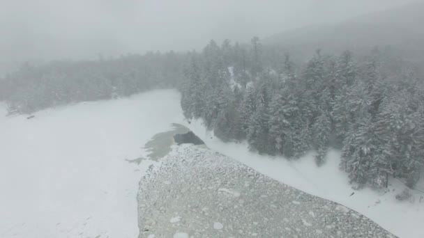 冬季无人驾驶飞机飞越北方森林结冰湖面时看到的严重暴风雪 — 图库视频影像