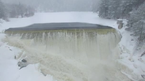 北米の降雪時に冬に滝の上に上昇するドローン — ストック動画
