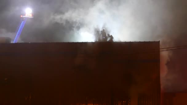 Rauch Aus Industriegebäude Mit Kleiner Gruppe Von Feuerwehrleuten Auf Dach — Stockvideo