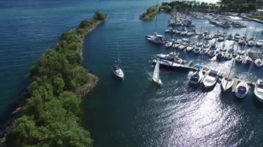 Okyanus kıyısındaki marinada yavaşça ilerleyen iki teknenin havadan görüntüsü.