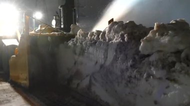 Büyük korkunç makine karı yer ve gecenin karanlığında uzağa fırlatır.