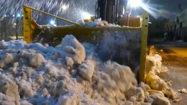 Karları ezen büyük kar makinesinin önünde duran kameraman.