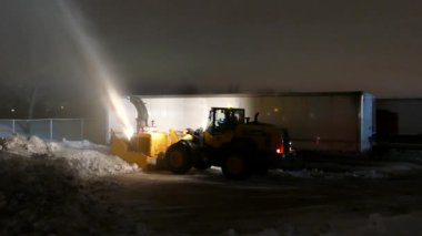 Çok güçlü kar temizleme makineleri yarı kamyonun yanına kar üflüyor.