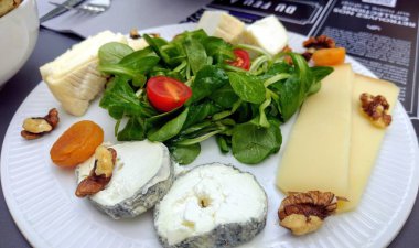 Bir tabak çeşit peynir ve yeşil salata, Fransa