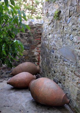 Eski taş duvar kalıntıları boyunca eski avluda Gigant kil şarap sürahi, Ikalto, Gürcistan
