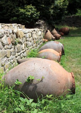Eski taş duvar kalıntıları boyunca eski avluda Gigant kil şarap sürahi, Ikalto, Gürcistan