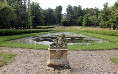 Önünde heykel olan eski gölet ve arka planında kubbe olan İsveç 'teki Sturefors Kalesi.