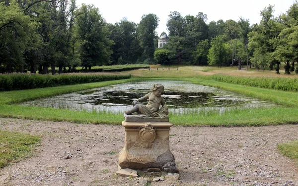 Önünde heykel olan eski gölet ve arka planında kubbe olan İsveç 'teki Sturefors Kalesi.