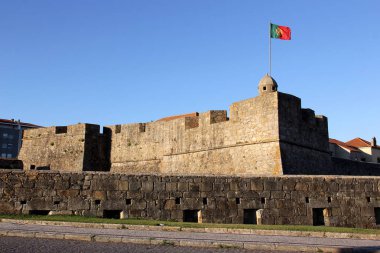Eski Fort Saint John The Baptist (Fortaleza de Sao Joao Baptista) kule üzerinde Portekiz bayrağı ile batan güneş, Porto, Portekiz tarafından aydınlatılmış