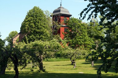 Eski gotik kilise ve elma bahçesinde ahşap kırmızı çan kulesi, İsveç