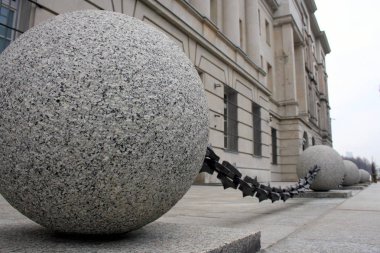 Arka planda klasik bina cephesi ile zincir, mimari detay, bağlı taş küreler, Varşova, Polonya