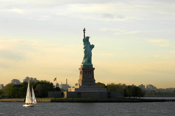 Statue of Liberty at sunset with a golden sunlit sky