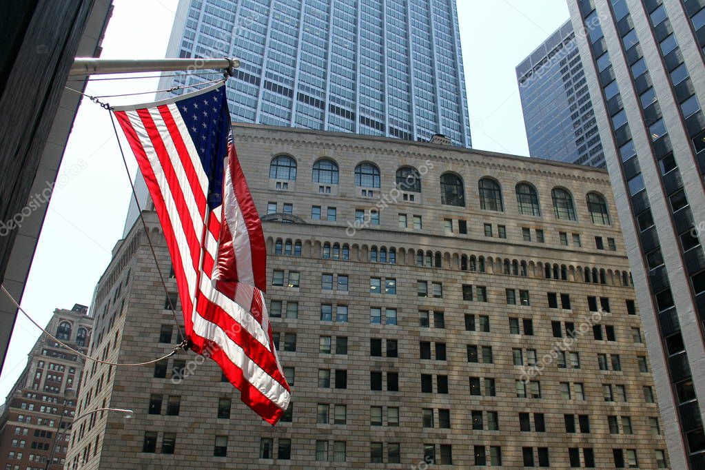 US Flag flying on the background of the facade of the Federal Reserve building in New York