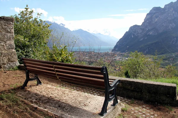 町や湖を見下ろす丘の斜面に木製のベンチ リヴァ ガルダ イタリア — ストック写真