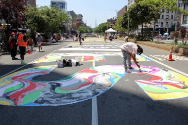 Activists paint huge Black Lives Matter sign on the road of Adam Clayton Powell Jr Blvd, Central Harlem, New York, NY, USA - July 5, 2020 clipart