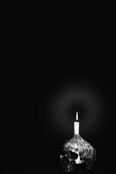 Czarno-biała czaszka Humen z oświetleniem świecy na ciemnym grzbiecie — Zdjęcie stockowe