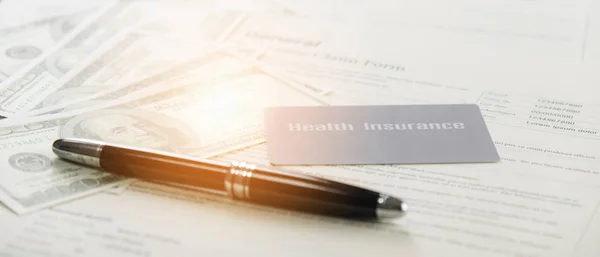 health insurance card and bank note and pen on background of gen