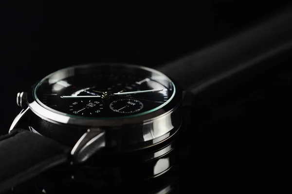 Primer plano del reloj de pulsera sobre fondo negro —  Fotos de Stock