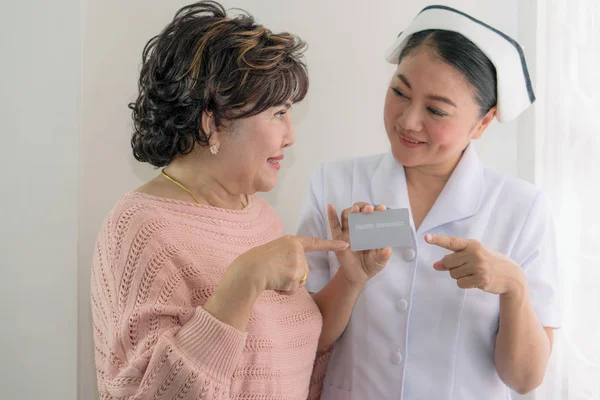 Asian senior patient and asian nurse point to health insurance c