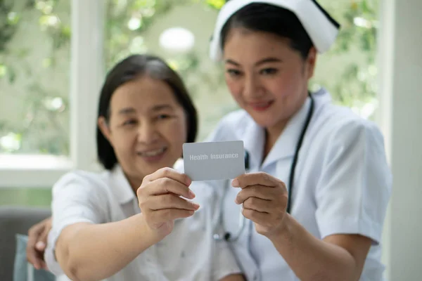 Kvinnlig asiatisk Senior patient pratar med sjuksköterska som håller Healt — Stockfoto