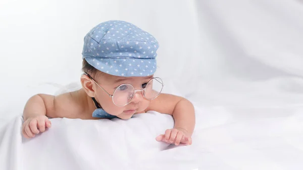 Portrait of asian infant baby boy with blue cap and glasses on w — Stock Photo, Image