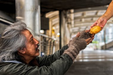 Mutlu yüzü ile evsiz erkek ekmek fro almak için elleri gösteren
