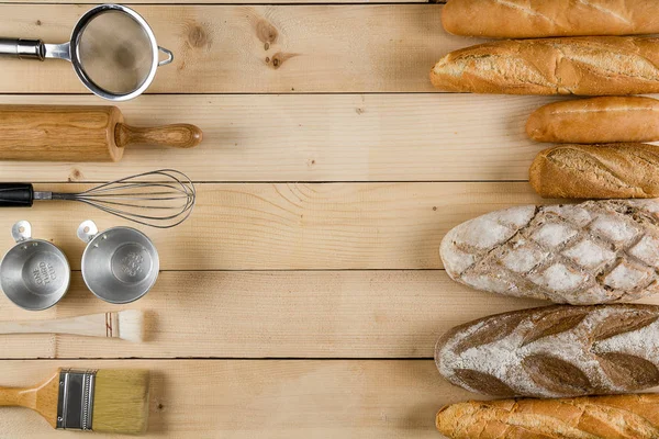 Різноманітні види хліба на дерев'яному столі з різноманітністю випічки — стокове фото