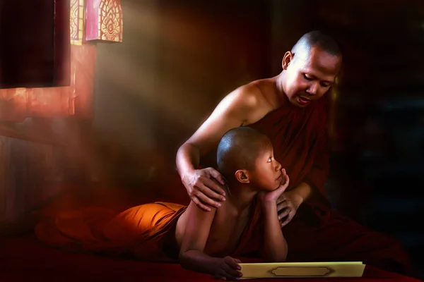 Thai Buddhist monk teaching Buddhist novice Buddhism lessons fro — Stockfoto