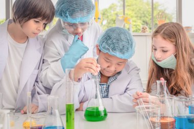 Beyaz ve Asyalı öğrenciler sci kimya deneyleri yapıyor