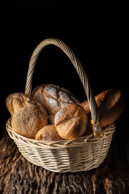 food background of a basket with assortment of bread on wooden p