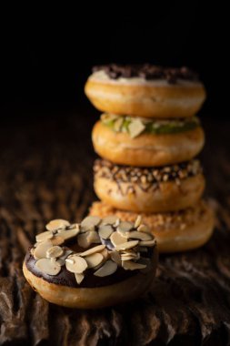 o arkasında çörek yığını ile ahşap kalas üzerinde çörek bir parça