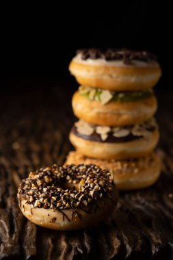 o arkasında çörek yığını ile ahşap kalas üzerinde çörek bir parça